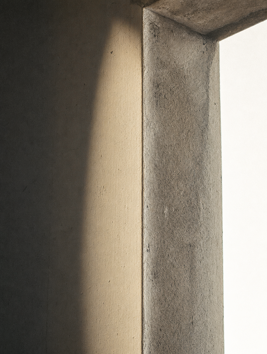Angle d'un tableau de fenêtre vu de l'intérieur, l'enduit du mur intérieur d'un côté et le nu de la façade de l'autre